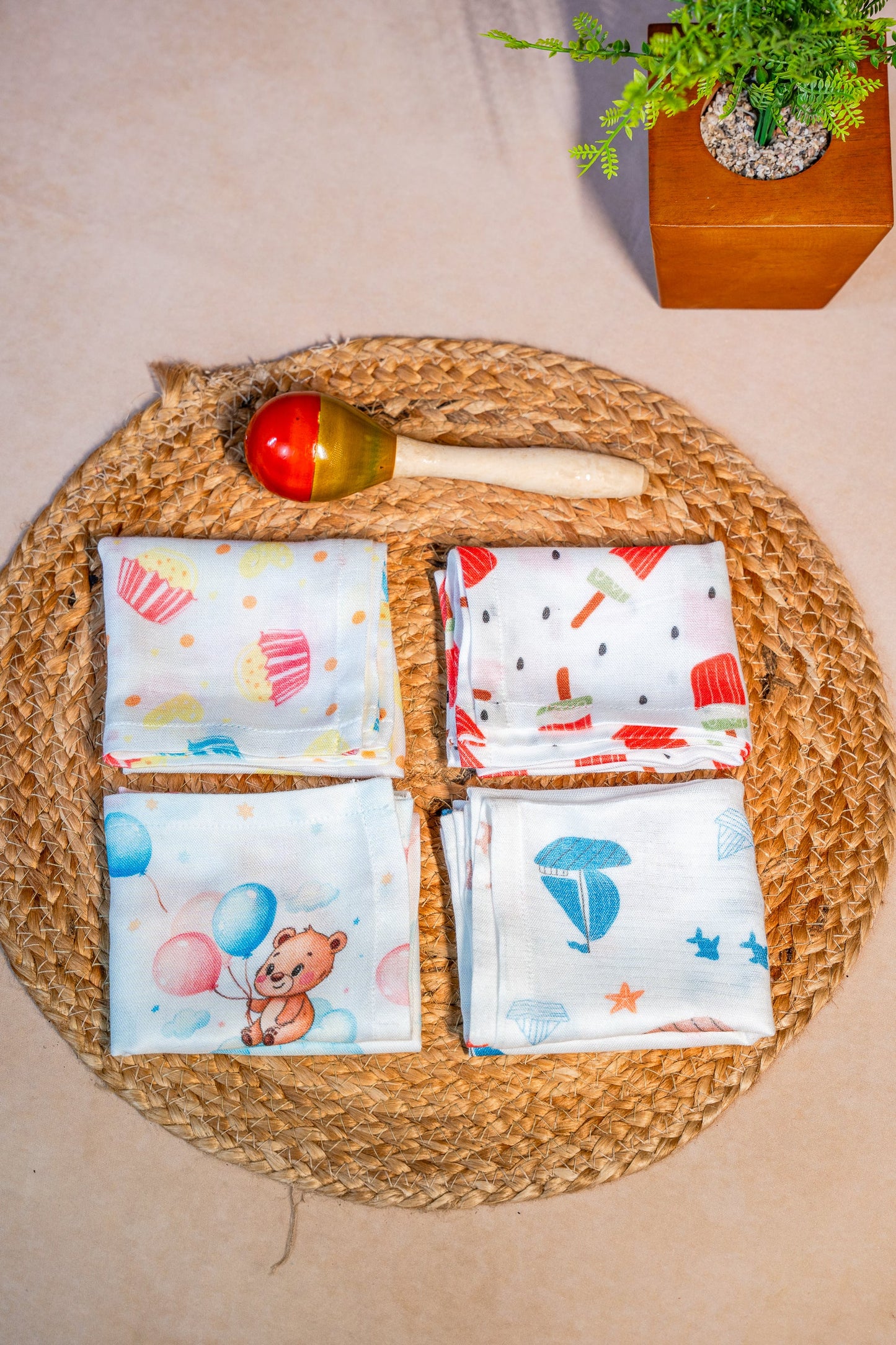 Four colorful fabric swatches on a woven mat with a wooden spoon and decorative items.